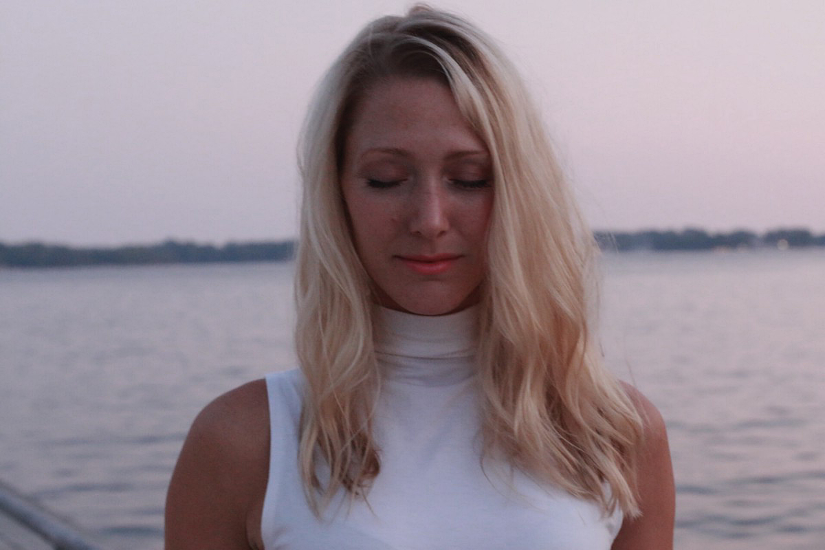 female-meditating-river-setting